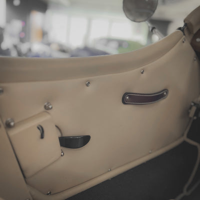 Close-up of a vintage car door with a blurred background