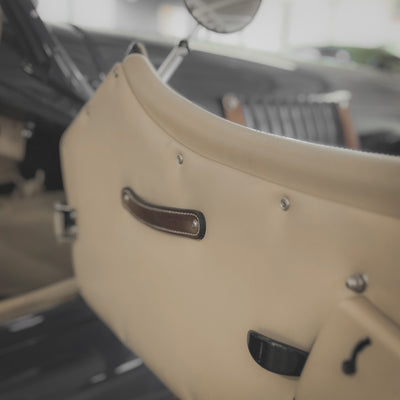 Close-up of a beige leather seat with stitching details in an indoor setting