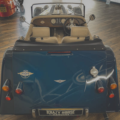 Vintage blue car with 'Krazy Horse' branding on a wooden floor.