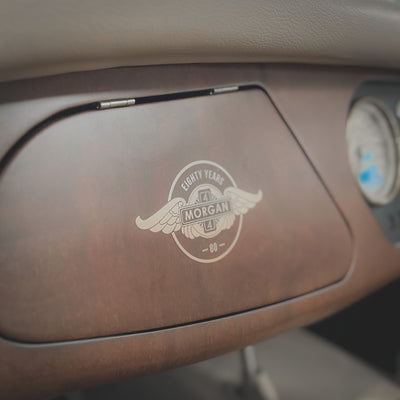 Close-up of a car's dashboard with a logo on a brown panel.
