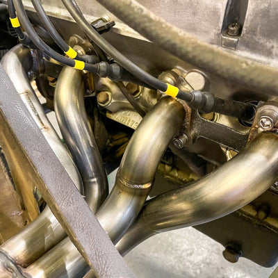 Close-up of mechanical components with pipes and wiring on a vehicle.