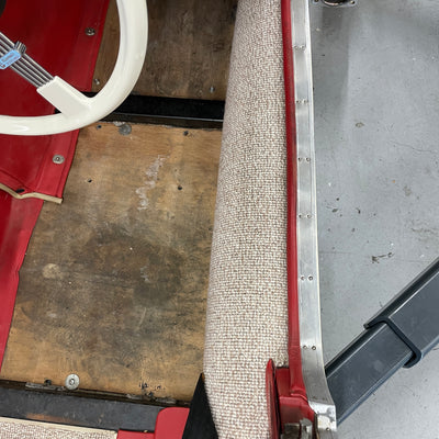 Close-up of a textured metal strip with red border on a concrete floor.
