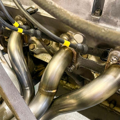 Close-up of metal pipes and wiring in an engine compartment