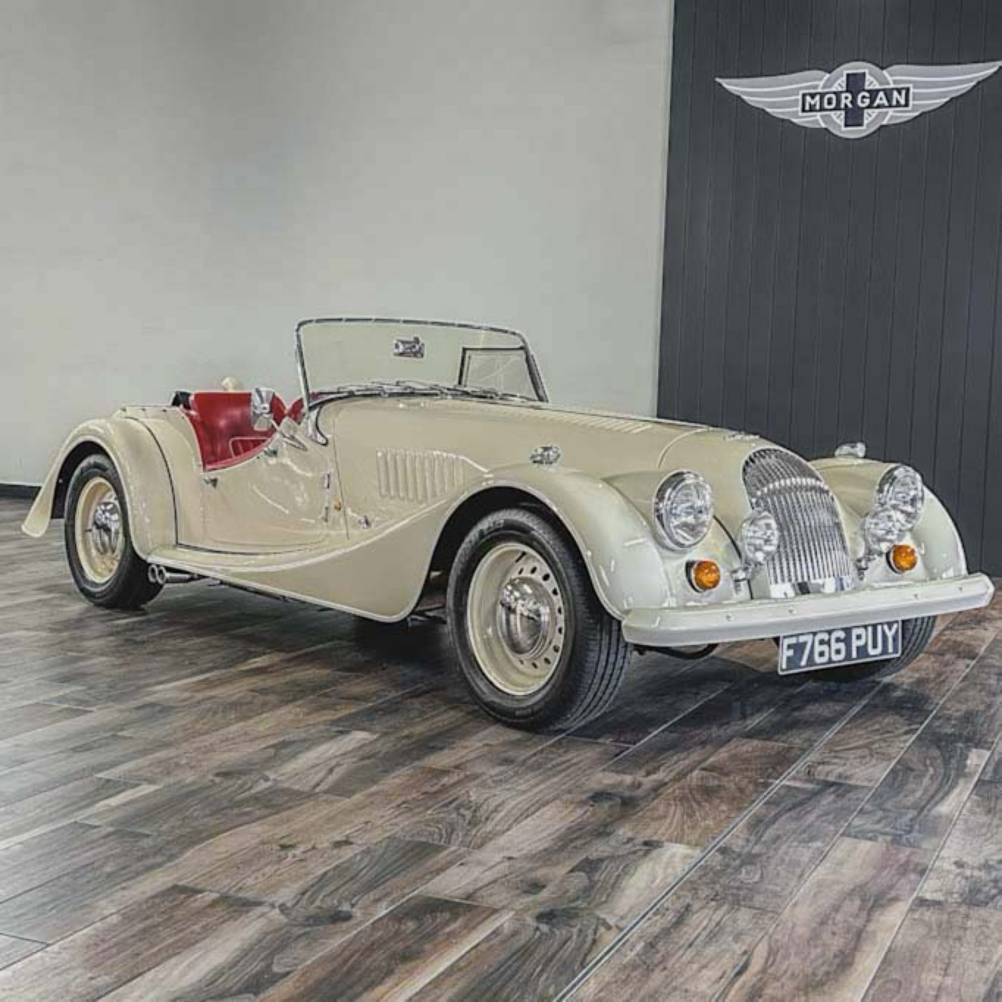 Vintage car on display with a branded wall in the background
