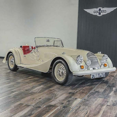 Vintage car on display with a branded wall in the background