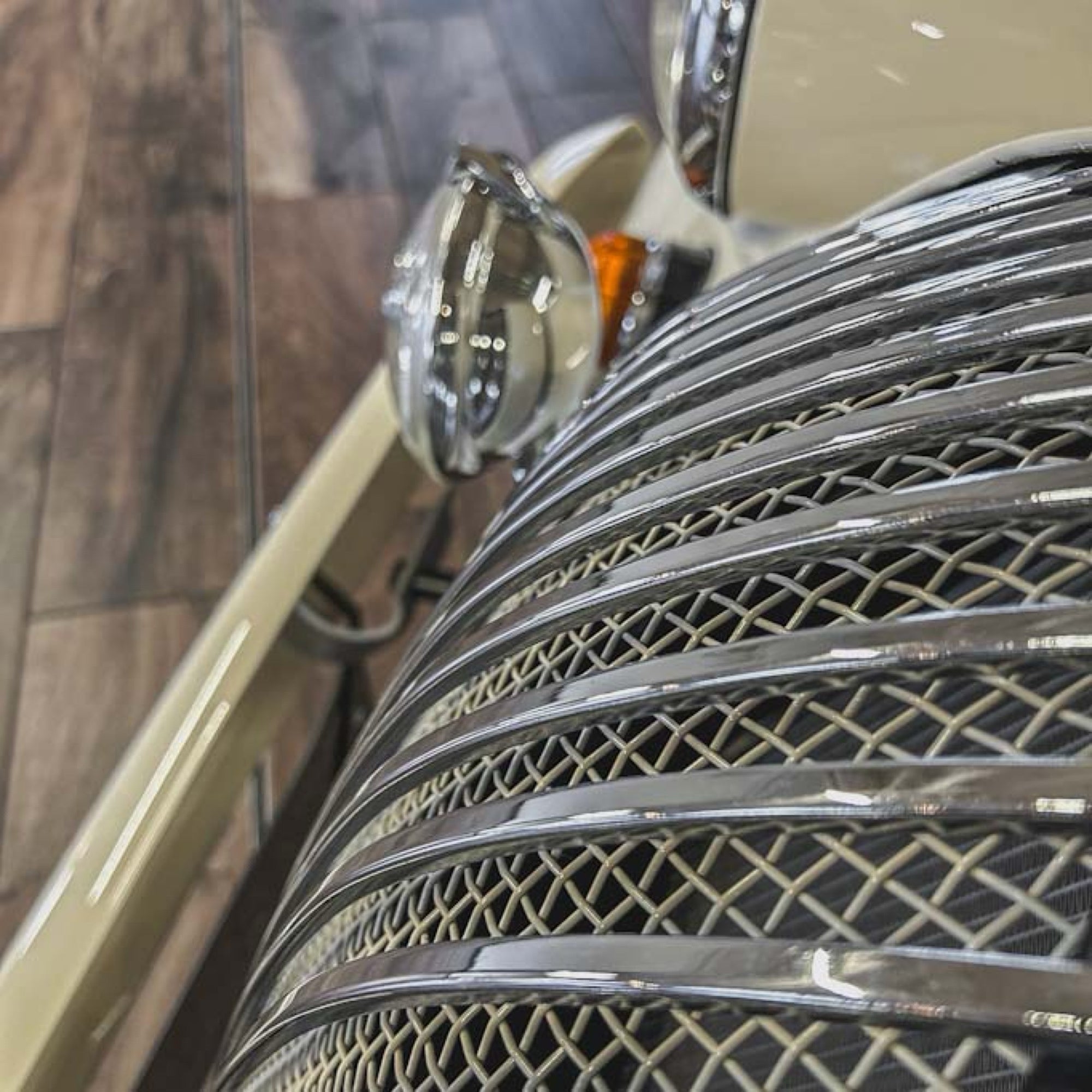 Close-up of a car's grille with a detailed mesh pattern