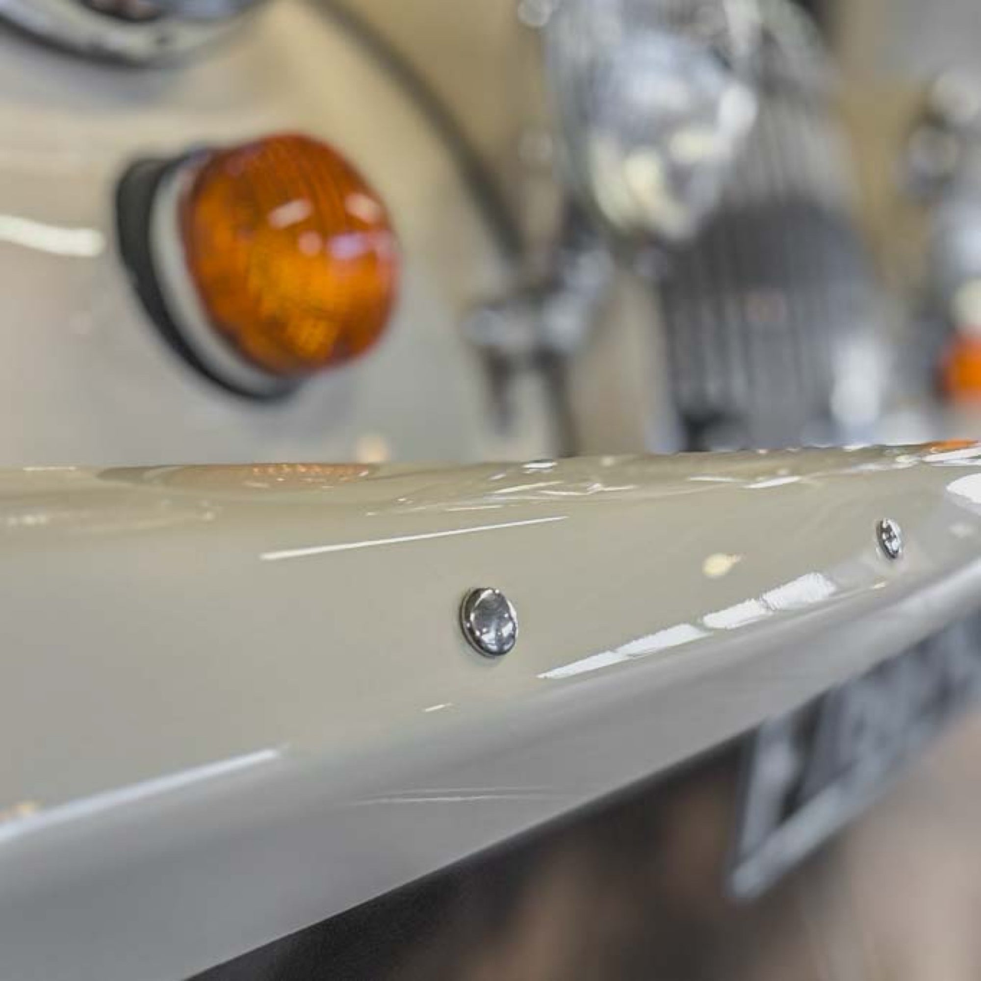 Close-up of a motorcycle's turn signal and front fender.