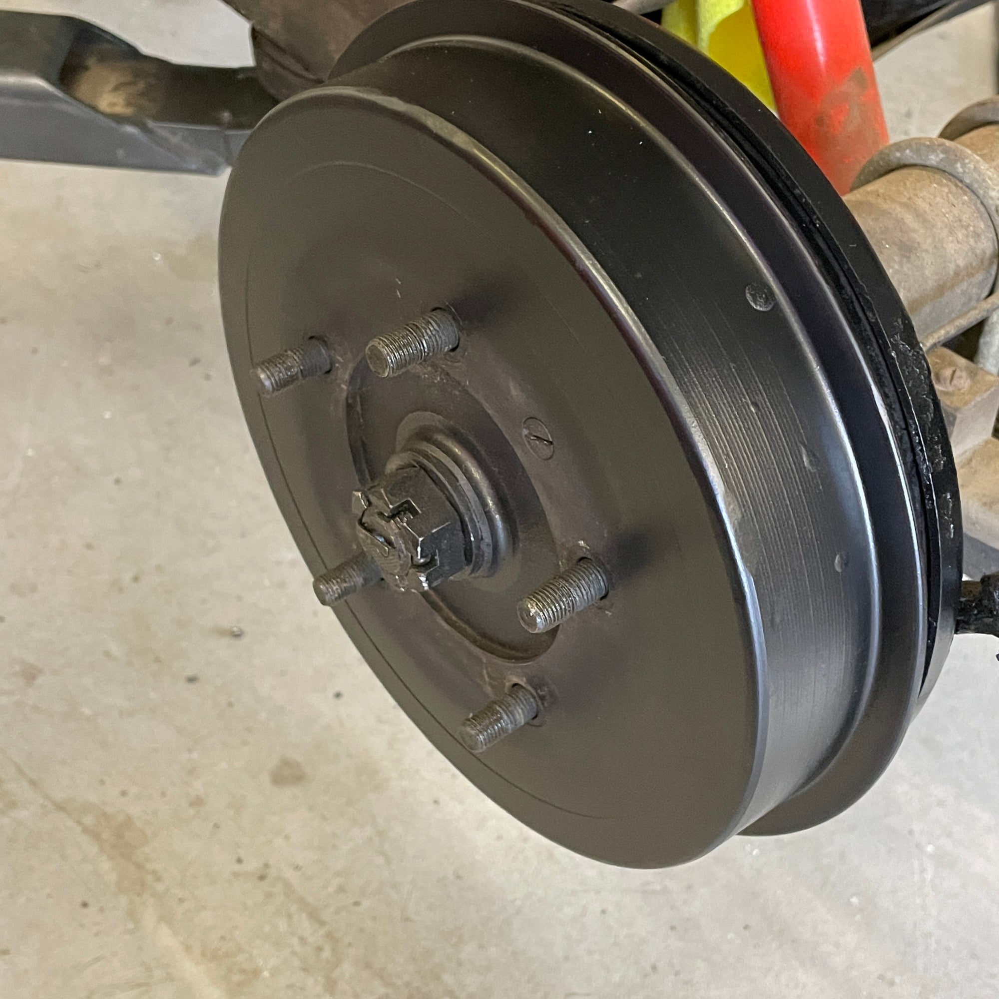 Close-up of a car brake drum on a concrete floor
