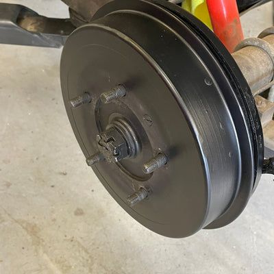 Close-up of a car brake drum on a concrete floor