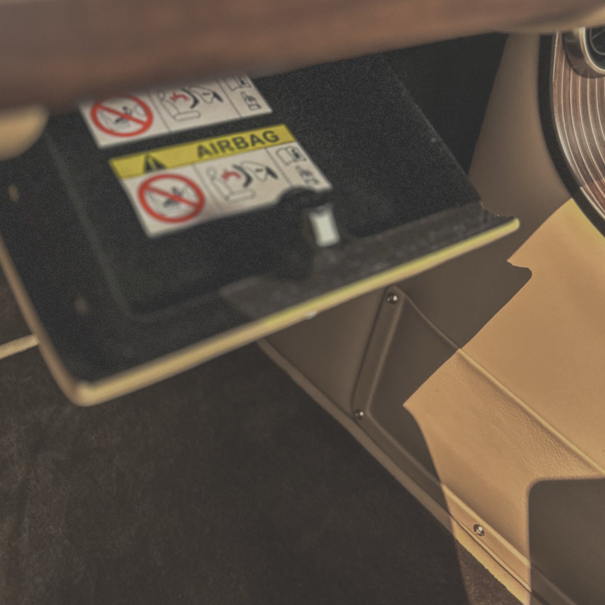 Car interior with airbag deployment cover and warning labels.