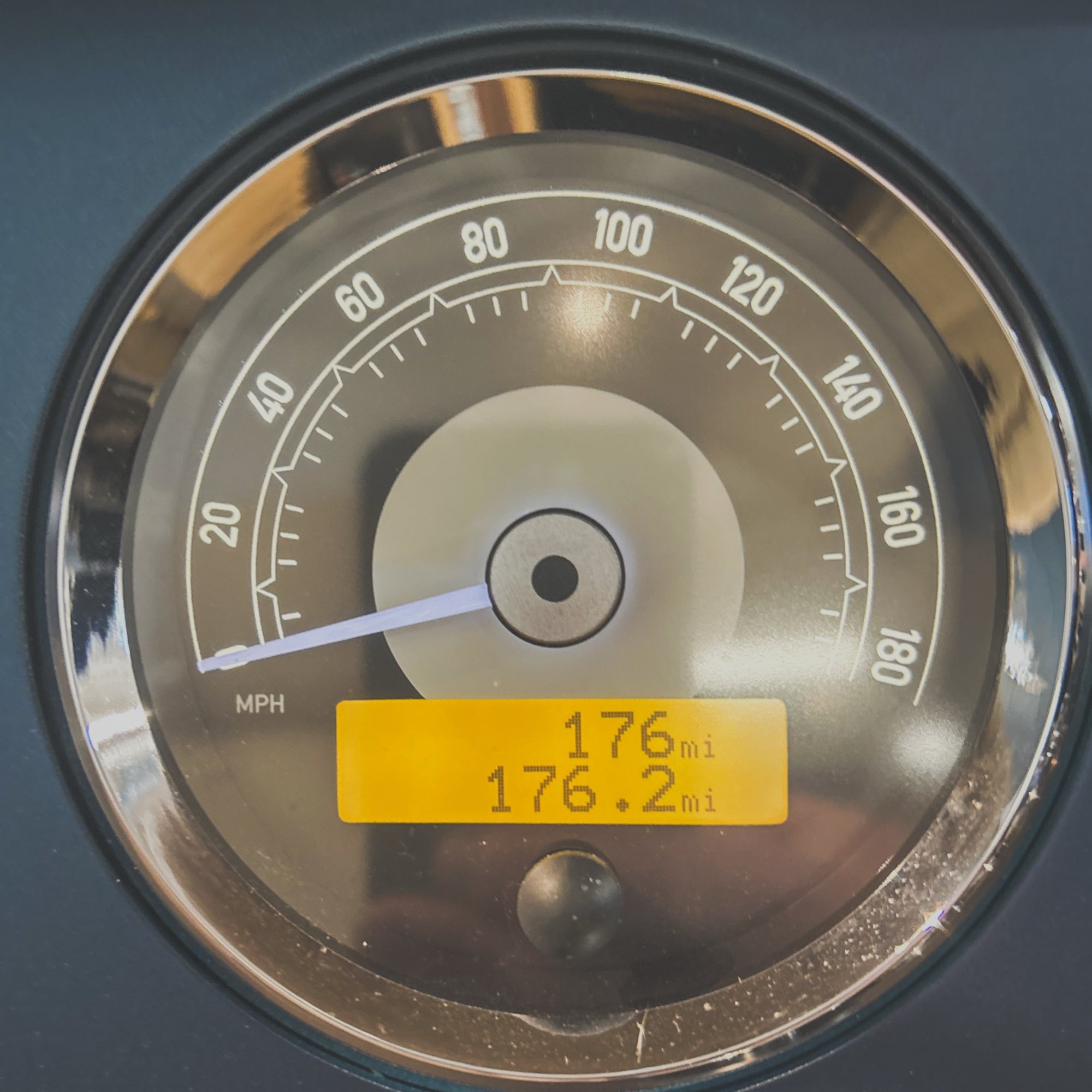 Close-up of a vehicle's speedometer with a yellow display showing mileage.