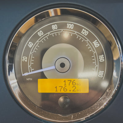 Close-up of a vehicle's speedometer with a yellow display showing mileage.