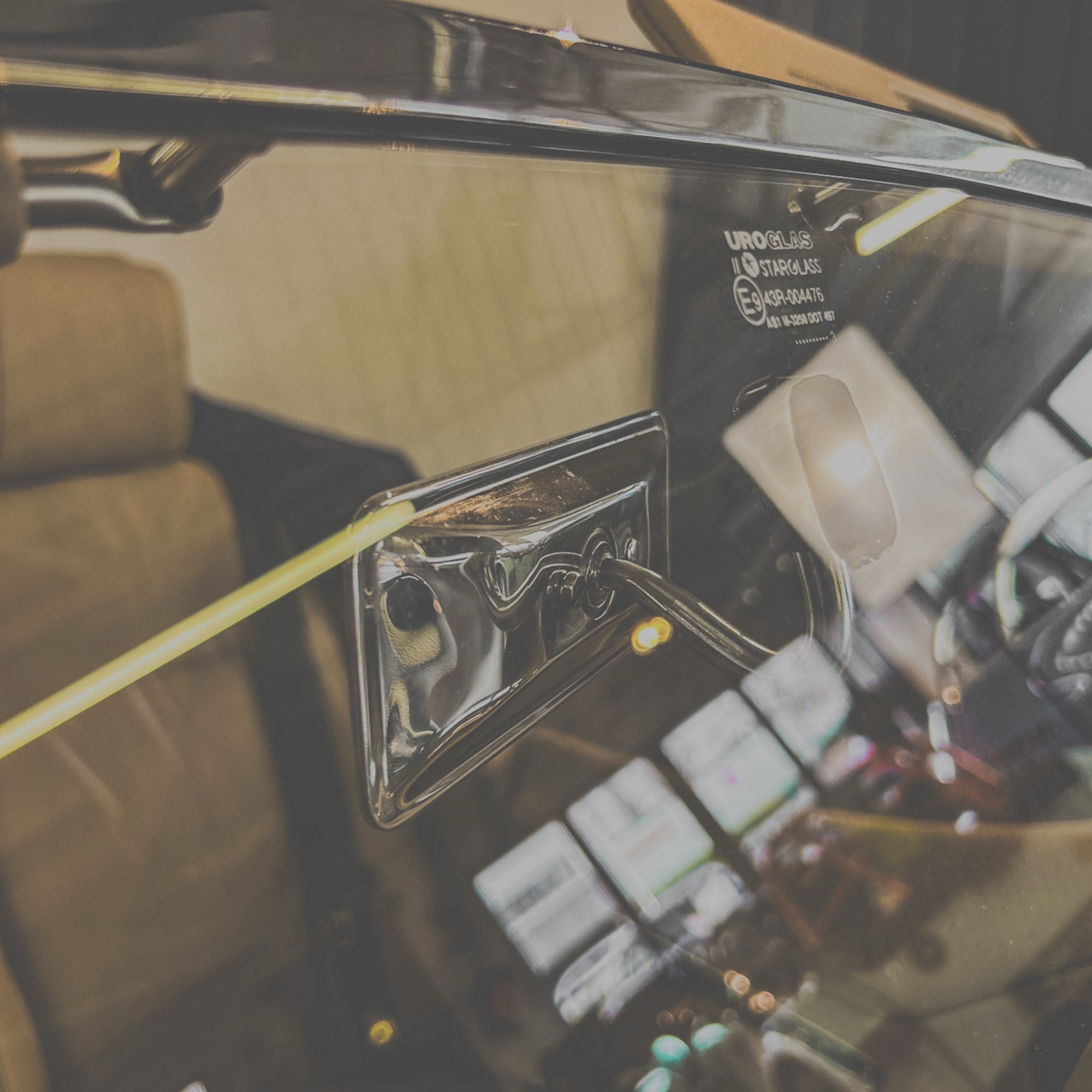Close-up of a car's interior with a focus on the door handle and dashboard.