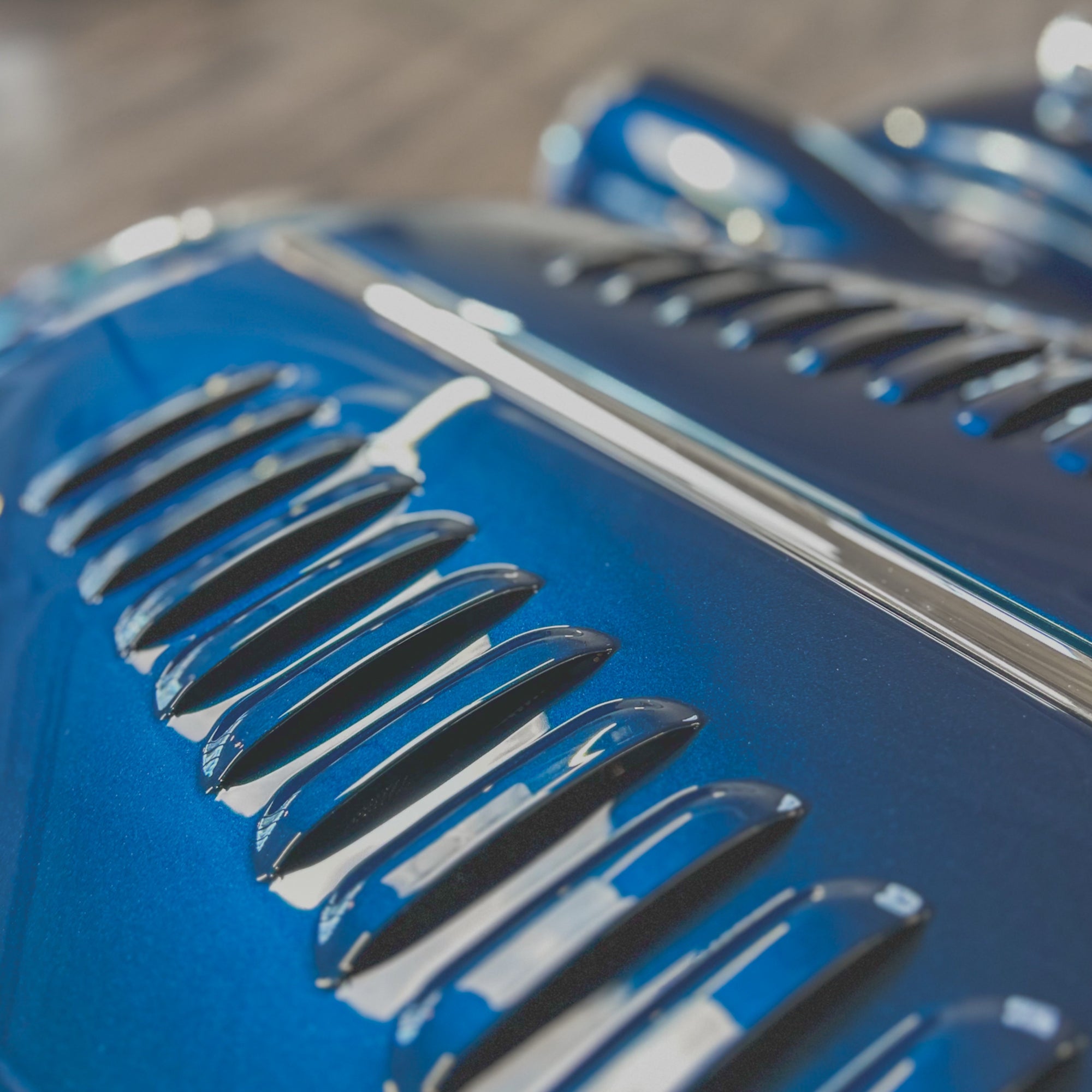 Close-up of a blue car grille with a blurred background