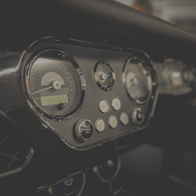 Close-up of a motorcycle dashboard with gauges and controls.
