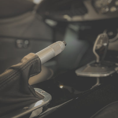 Close-up of a hand holding a car key in a vehicle's ignition.