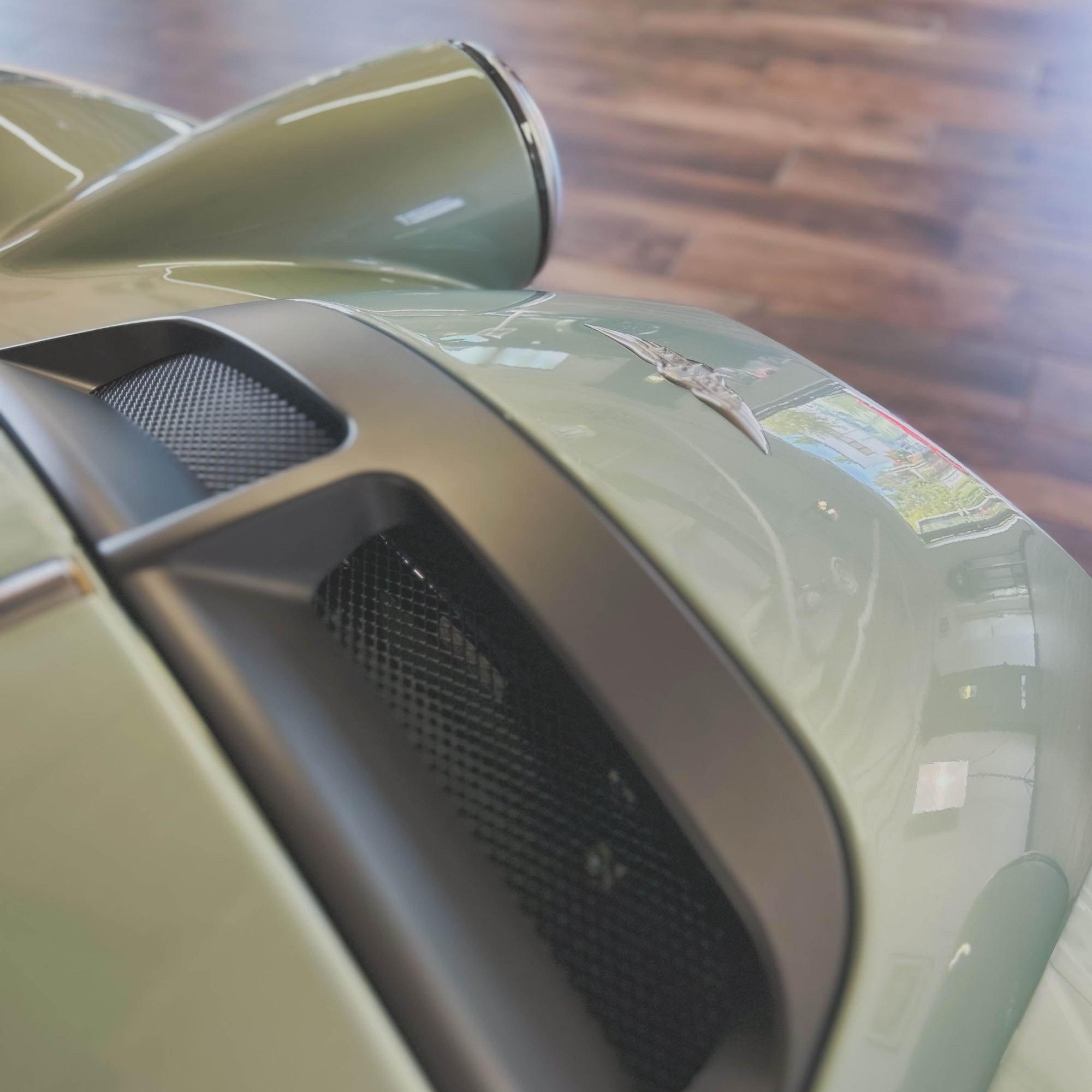 Close-up of a car's side mirror and air vent with a blurred background