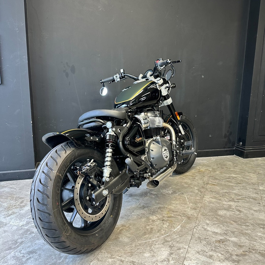 Motorcycle parked indoors against a dark wall