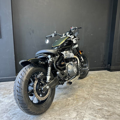 Motorcycle parked indoors against a dark wall