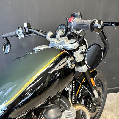 Close-up of a motorcycle's handlebar and front section against a dark background