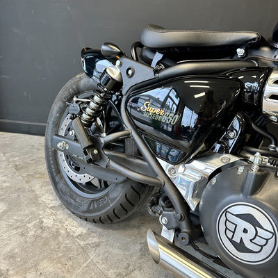 Close-up of a black motorcycle with visible branding on a gray floor.