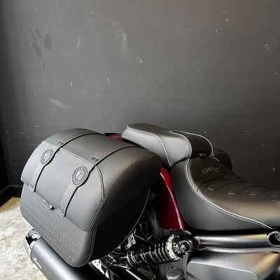 Gray motorcycle seat and saddlebags against a dark background