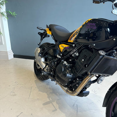 Motorcycle with visible branding on a light-colored floor against a gray wall.