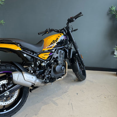 Yellow and black motorcycle against a gray wall