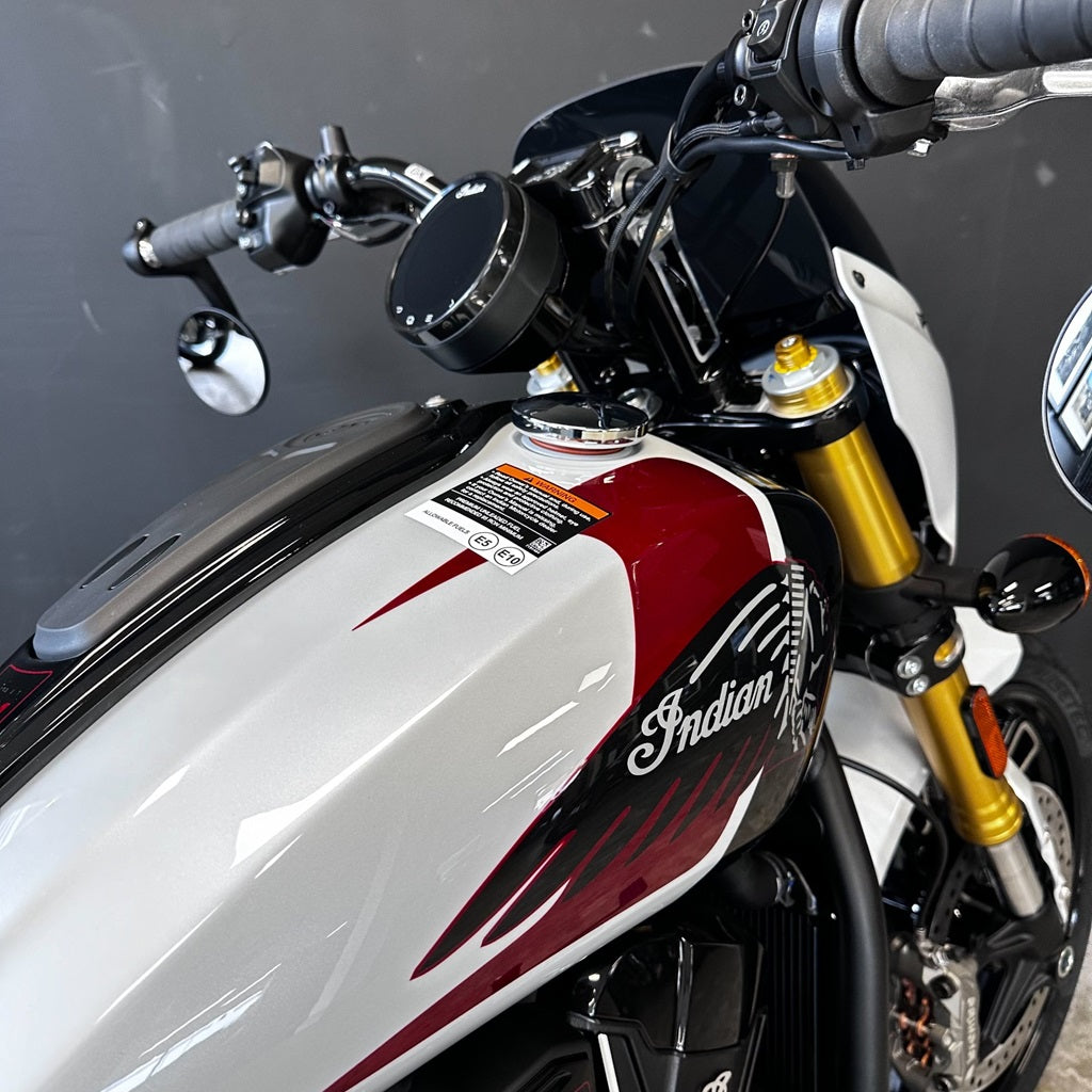 Close-up of a motorcycle with 'Indian' branding on a gray background