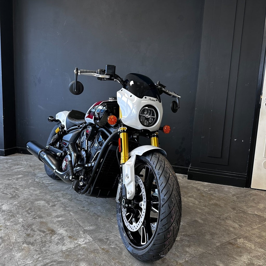 Motorcycle parked indoors against a dark wall