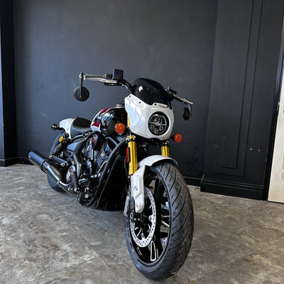 Motorcycle parked indoors against a dark wall
