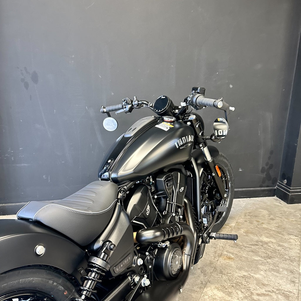 Black Indian motorcycle parked against a gray wall.