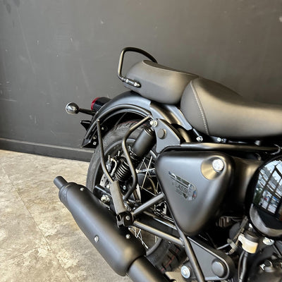 Close-up of a black motorcycle with visible branding against a dark background