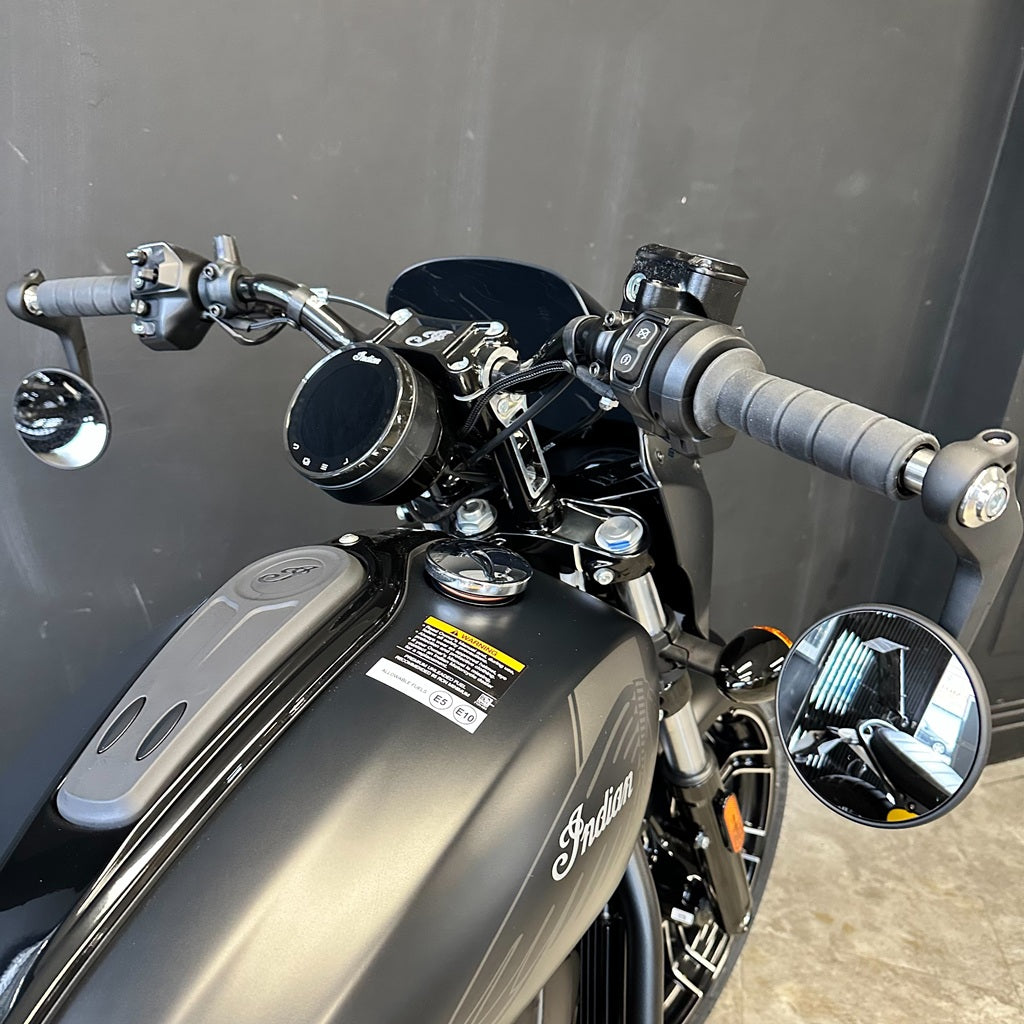 Close-up of a motorcycle handlebar with 'Indian' branding against a gray background