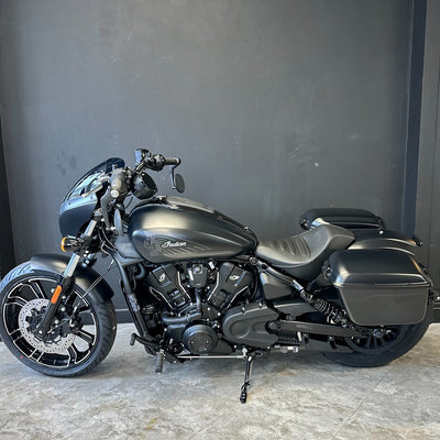Black motorcycle parked against a gray wall