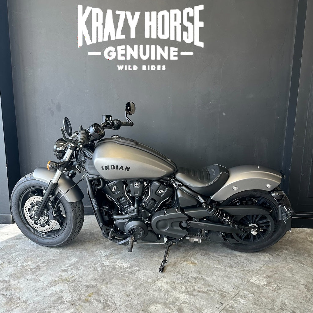 Motorcycle parked in front of a wall with 'Krazy Horse Genuine' branding.