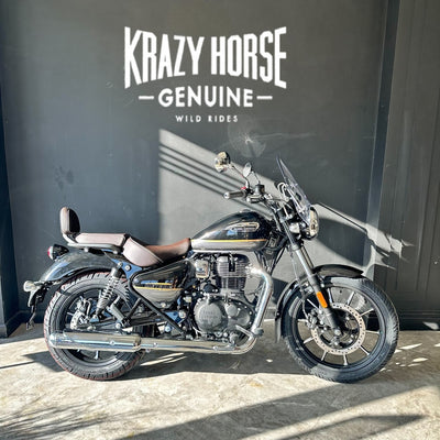 Motorcycle parked in front of a wall with 'Krazy Horse Genuine' branding.
