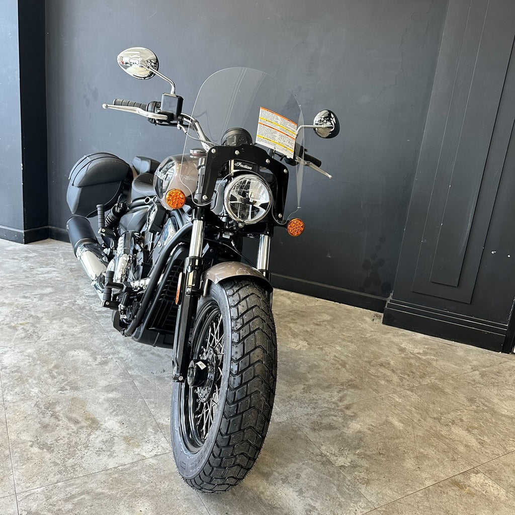 Black motorcycle parked indoors against a dark wall.