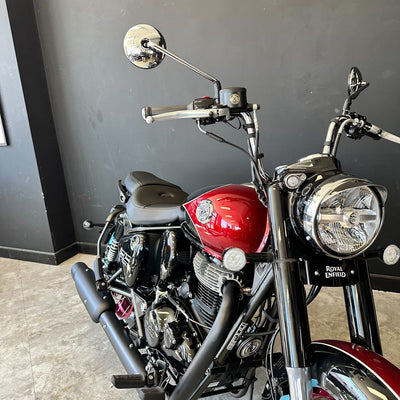 Red and black motorcycle parked indoors against a dark wall.