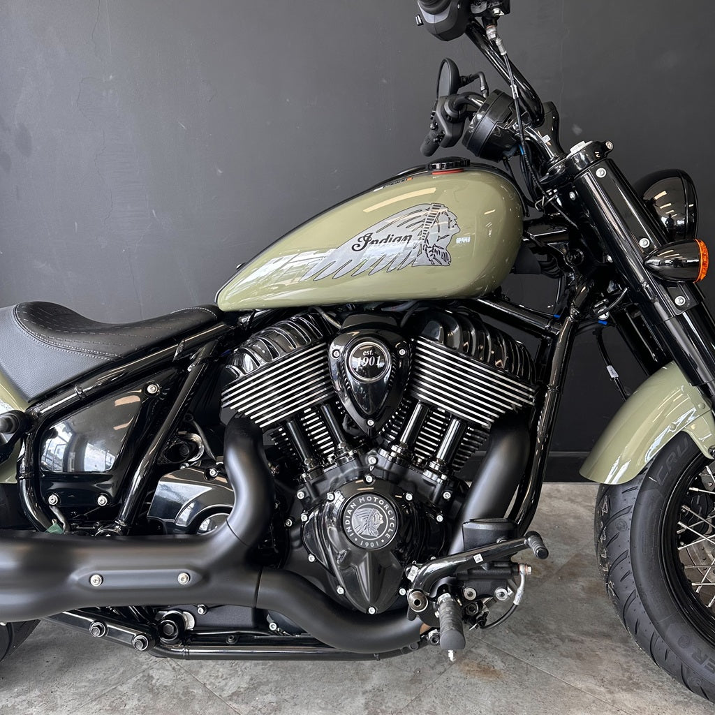 Close-up of a motorcycle with a visible brand logo on a gray background