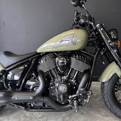 Close-up of a motorcycle with a visible brand logo on a gray background