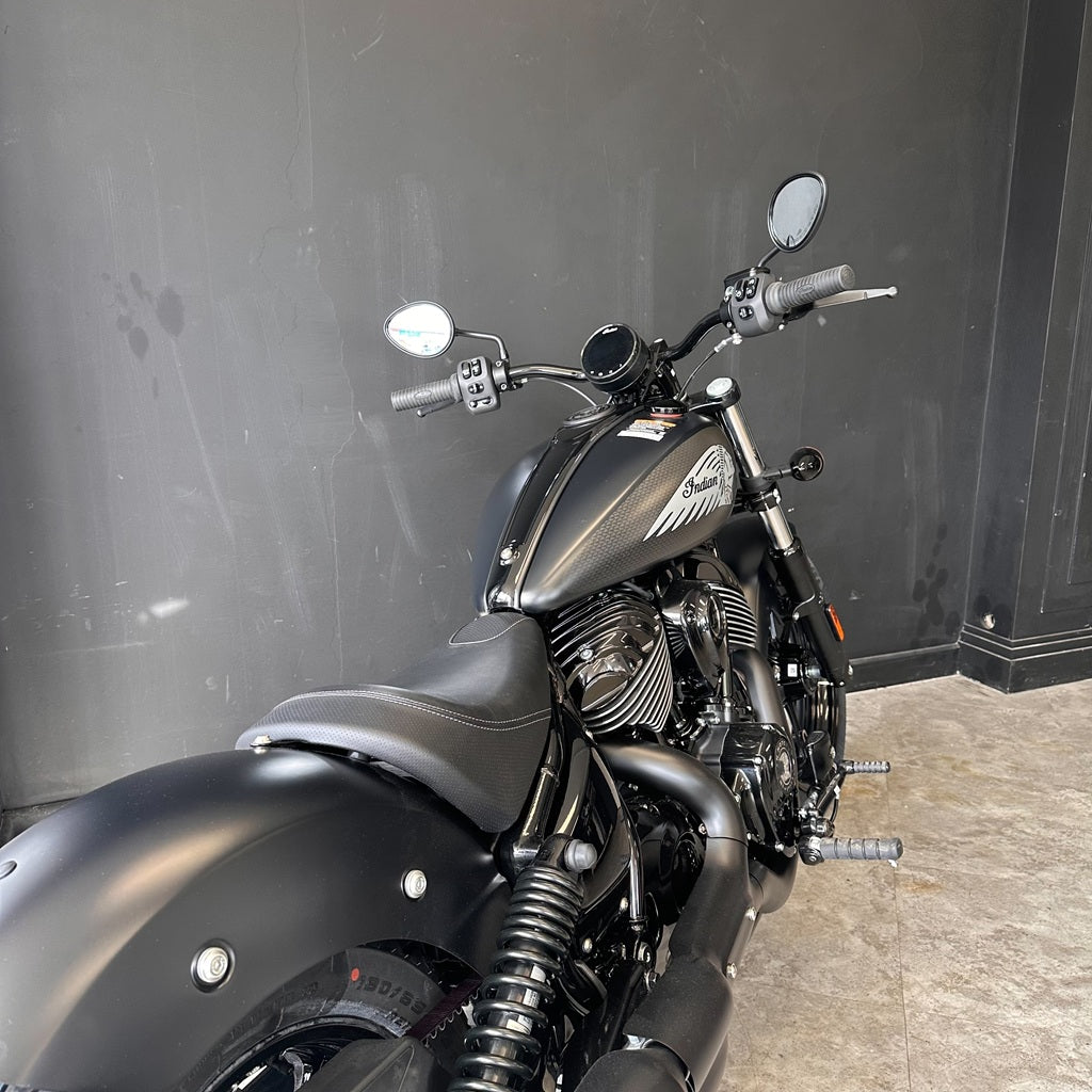 Black motorcycle parked against a dark wall