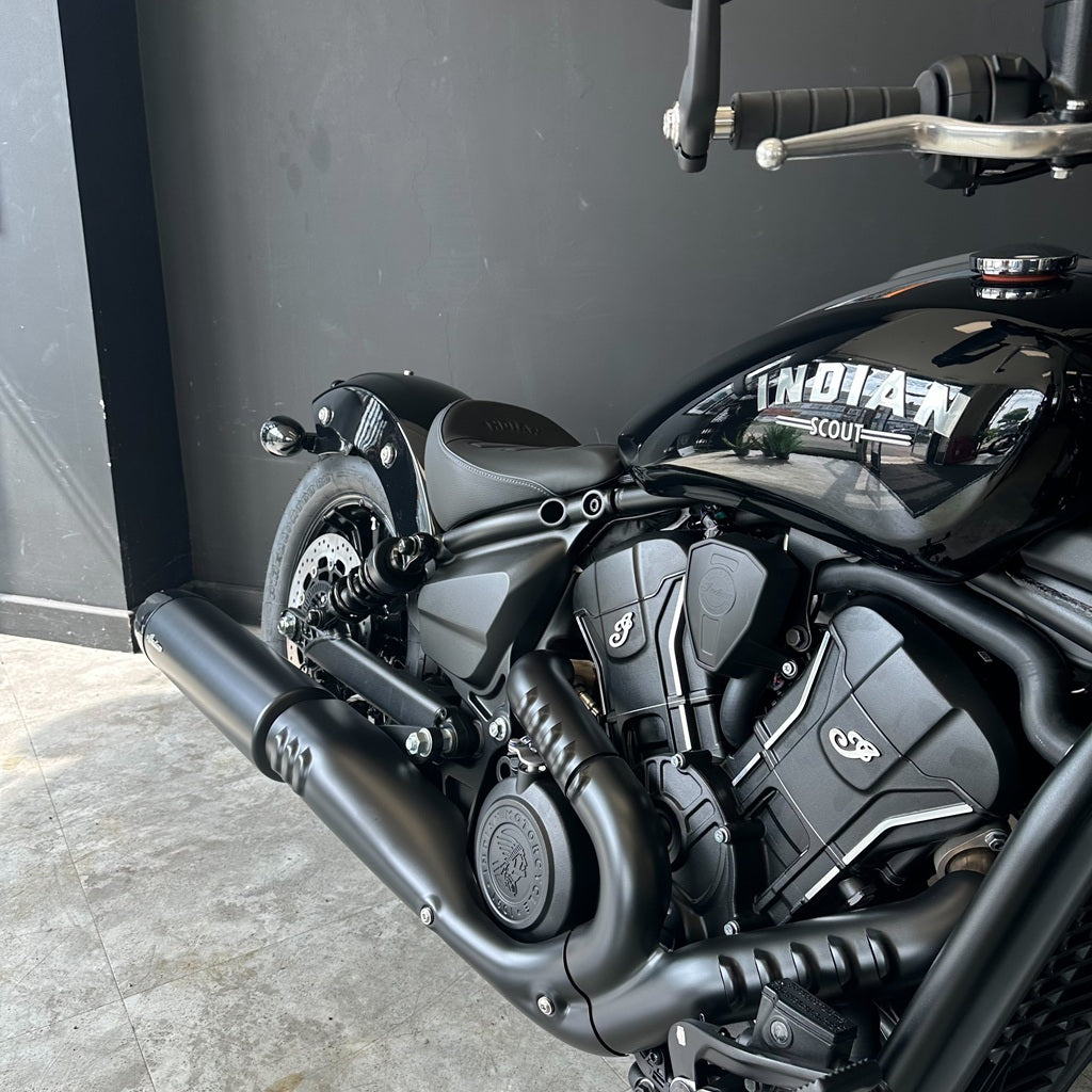 Close-up of a black cruiser motorcycle with a matte black finish, featuring a custom 'TWENTYTWO' decal on the side panel, set against a dark gray wall.