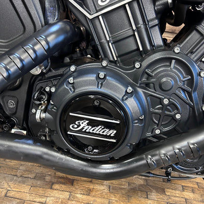 Close-up of a motorcycle engine with 'Indian' branding on a wooden floor.