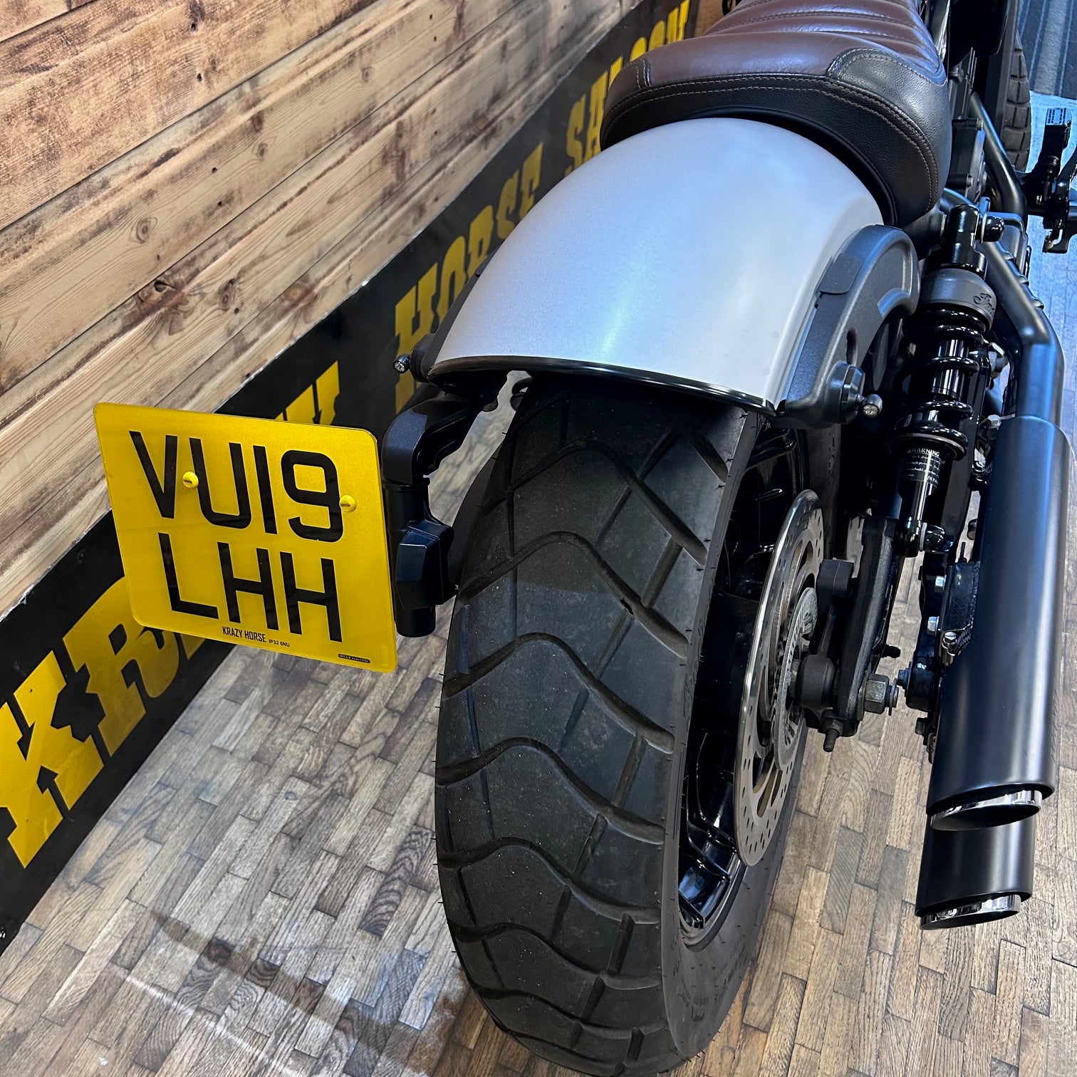 Motorcycle with a yellow license plate on a wooden floor