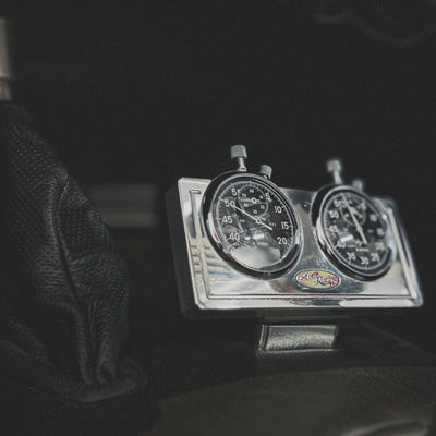 Close-up of a vintage speedometer and tachometer in a car dashboard.