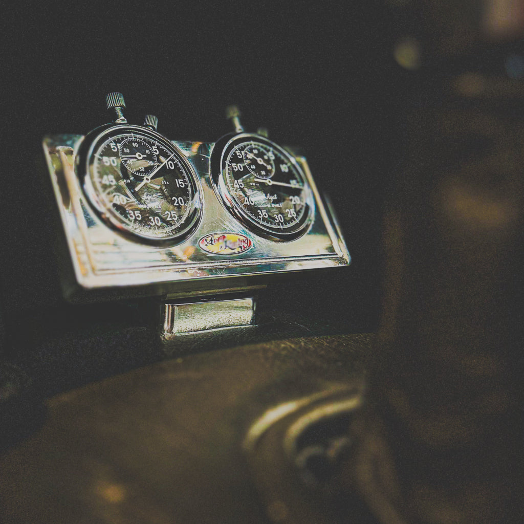 Vintage car dashboard with speedometer and tachometer on a dark background