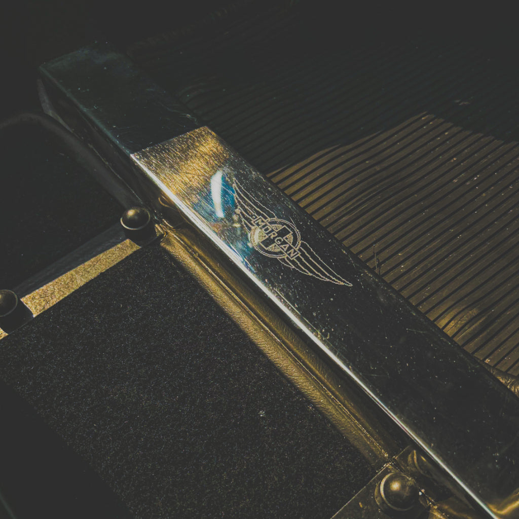 Close-up of a guitar pedal with a logo on a dark background