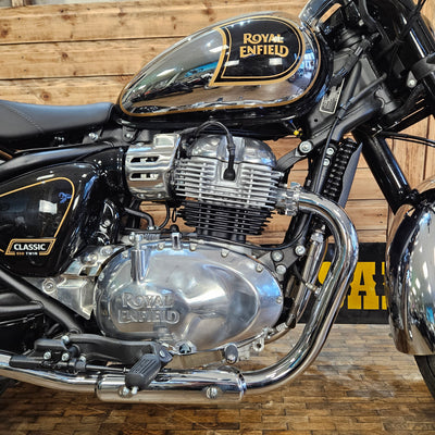 Close-up of a Royal Enfield motorcycle engine with wooden wall background