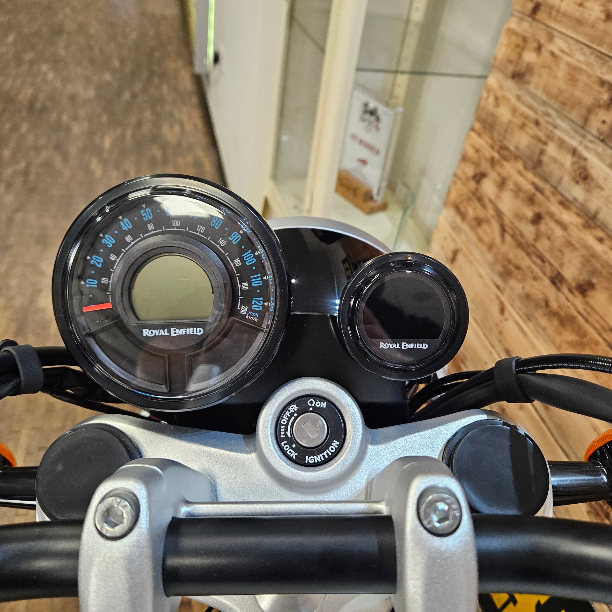 Close-up of motorcycle dashboard with speedometer and tachometer on a wooden background